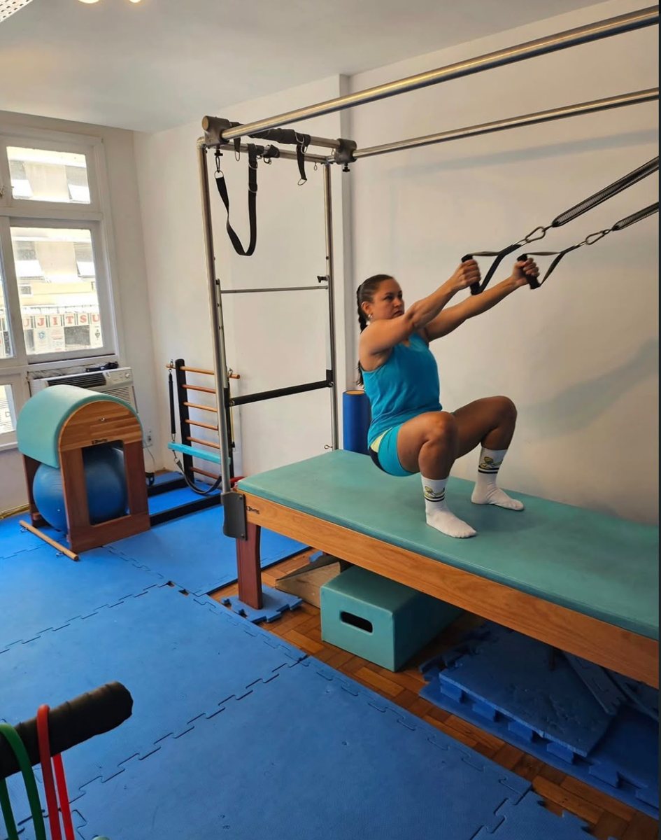 Aluna fazendo exercício no Cadillac de Pilates na sala do consultório