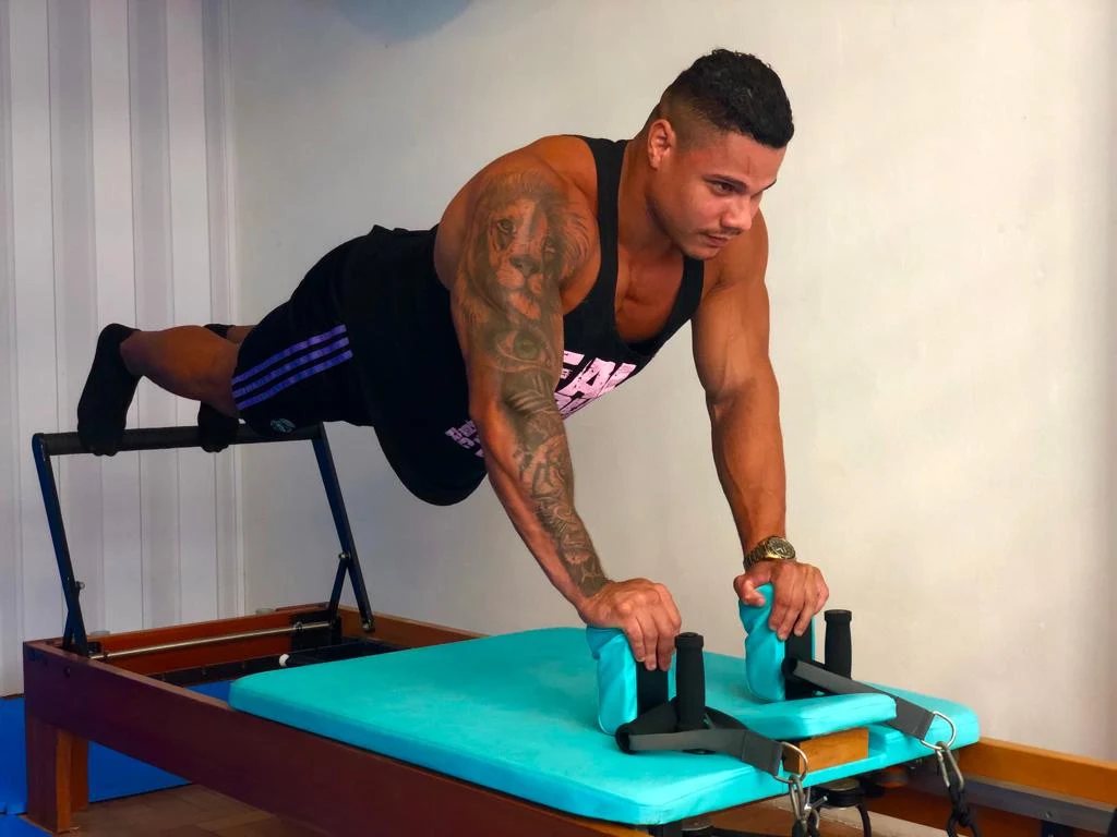 Aluno fazendo prancha no Reformer de Pilates