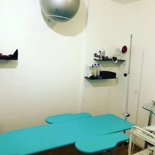 Sala de atendimento com maca e aparelhos de fisioterapia